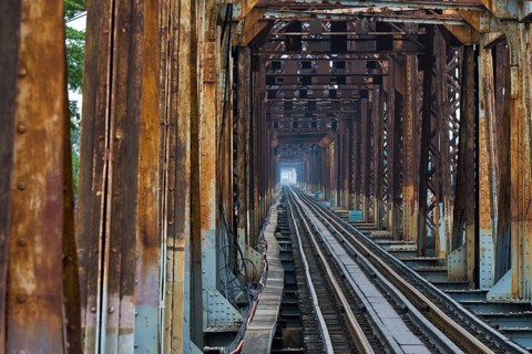 A Vietnamese State Railroad train crosses the Long Bien Railway Bridge across the Red River, Hanoi,