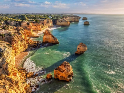 Aerial view of Praia da Marinha beach in Algarve, Portugal, with ocean cliffs, sea stacks and