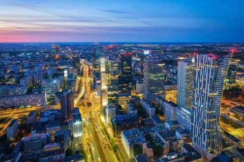Cityscape view of the Warsaw skyline in Poland with skyscrapers, city lights, traffic trails, blue