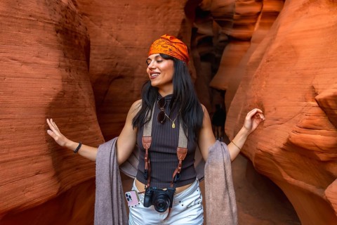 Woman joyfully experiencing the iconic sandstone walls of antelope canyon, touching the sculpted