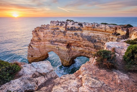 Sunrise view of Praia da Marinha beach in Algarve, Portugal, with golden cliffs, sea stacks,