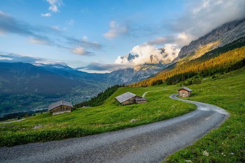 Road, alpine huts and alpine meadows, sunset, summit of the Wetterhorn in the back, Alpiglen,