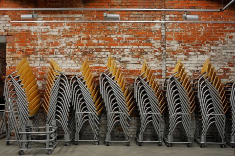 Modern stacking chairs in front of a brick wall, unfinished small hall of the NS Congress Hall from