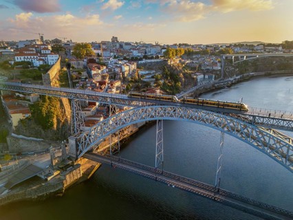Drone view of Dom Luis I Bridge over Douro River in Porto, Portugal, with the riverfront, including