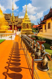 Prayer bells, hung in a row, gilded temple towers at the back, chedi, stupas in the Wat Phra Singh