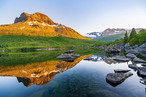 Picturesque mountain landscape in the Innerdalen high valley, mountain peaks reflected in Lake