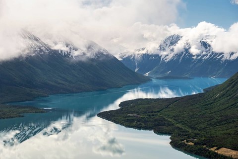 View of snowy mountains in spring and turquoise Kenai Lake with reflection, Slaughter Ridge Trail,