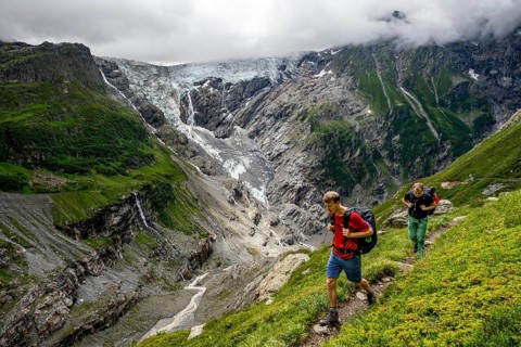 Mountaineers on a hiking trail, dramatic mountain landscape with Grindelwald-Fiescherfirn glacier,