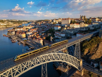 Drone view of Dom Luis I Bridge over Douro River in Porto, Portugal, with riverside quay, including
