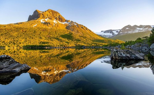 Picturesque mountain landscape in the Innerdalen high valley, mountain peaks reflected in Lake