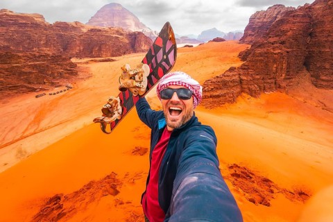 Excited rider pov pose selfie from top viewpoint on big red dune in Wadi Rum desert Jordan. Sand