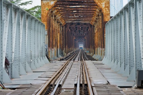 A train, locomotive, of the Vietnamese State Railways crosses the Long Bien railway bridge over the