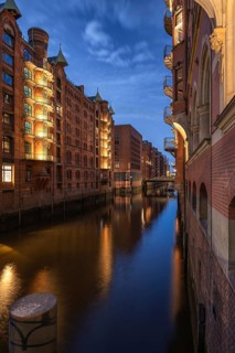 Historic brick warehouses are reflected in the calm water of the wall frame fleet of Hamburg's
