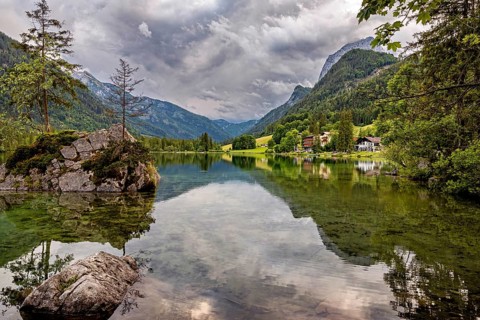 Mountain lake with crystal clear water, reflecting surroundings and surrounded by alpine idyll, The