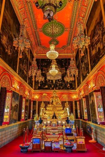 Beautifully furnished temple room with golden Buddha statue, sparkling chandeliers and