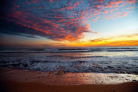 Colourful sky over the beach at sunset, with lively waves and rocks, sunset, Praia do Amado,