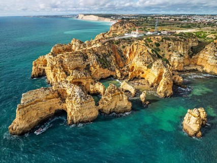 Drone view of Ponte da Piedade in Lagos, Algarve, Portugal, with sea stacks, cliff shadows and
