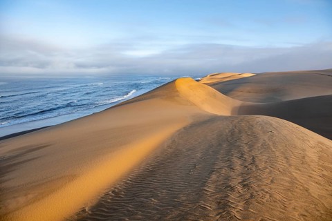 Sand dunes in morning light, view of Atlantic coast and sea, Sandwich Harbour, impressive desert