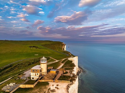 Sunset over Belle Tout Lighthouse from a drone, English Channel, Beachy Head Cliffs, East Sussex,