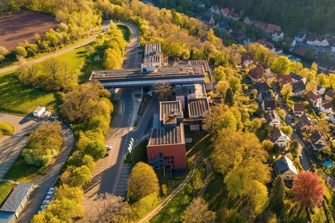 Aerial view of a building complex with roads and trees in an autumnal village environment, Calw