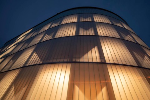 03.05.2026: Illuminated modern timber parking garage (Parkhaus am Bahnhof) with a curved wooden