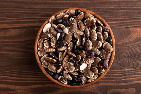 Wooden bowl with Kidney beans on brown wooden background, top view, flat lay, close up, minimalism