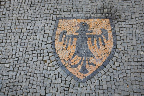City coat of arms with black eagle as floor mosaic, yellow coat of arms, eagle figure, paving