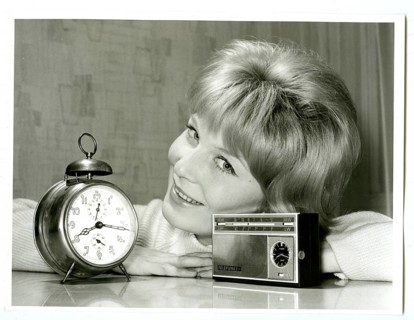 Transistor radio, with clock, versus alarm clock, advertising photography, smiling woman leaning at