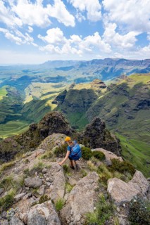 Female mountaineer hiking trail to Cathedral Peak or Cathedralpiek or Mponjwana, Drakensberg,