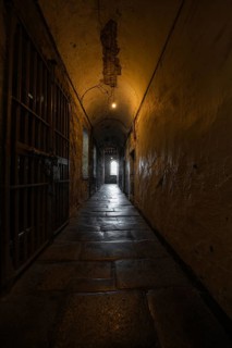 Long, dark prison corridor with stone vaulting, leading into light, Kilmainham Gaol Prison, Dublin,