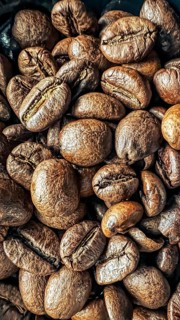Stacking coffee beans with visible texture and warm tint, coffee beans