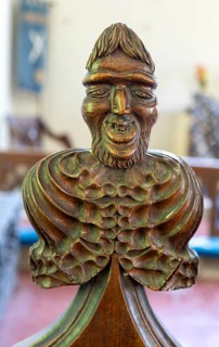 Carved wooden poppyhead face of man with beard, village parish church of Saint Andrew, Winston,