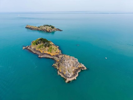 Aerial view of a small chain of islands in the turquoise sea off the coast of the municipality of