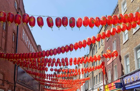 Red Chinese lanterns suspended over street in Chinatown, Little Newport Street, Soho, London,