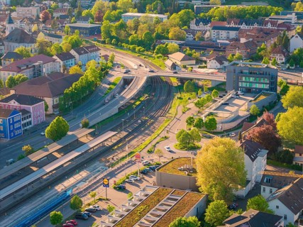 Urban environment with rails and roads, embedded in a green landscape, electrification of the