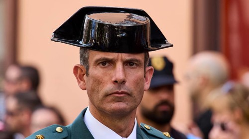 Man in green uniform wearing traditional hat at a street ceremony, Good Friday procession, Easter,