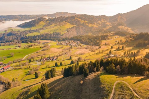A wide landscape view with villages, forests and mountains in sunlight, Allgäu, Bavaria, Germany