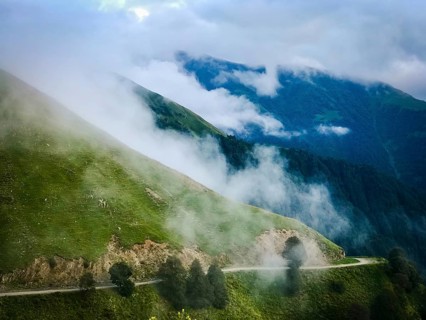 Scenic mountain gravel road in Tusheti region surrounded by foggy caucasus nature. Tusheti.Georgia