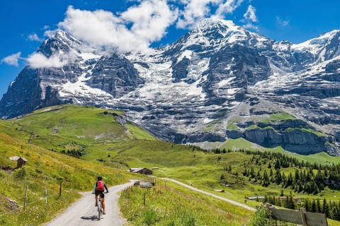 Woman riding her e-mountainbike below the Eiger northface, Jungfrauregion, Grindelwald, Bernese