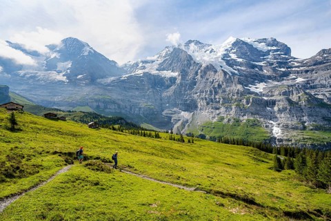 Two hikers on a hiking trail on Mettlenalp, mountain panorama with peaks Eiger, Mönch and Jungfrau,