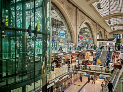 View of the shopping area in Leipzig Central Station with glass walls and stairs, train station,
