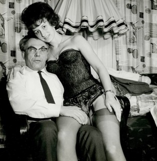 A man is sitting whilst a woman in lingerie sits provocatively on his lap, Herbert Jacobi