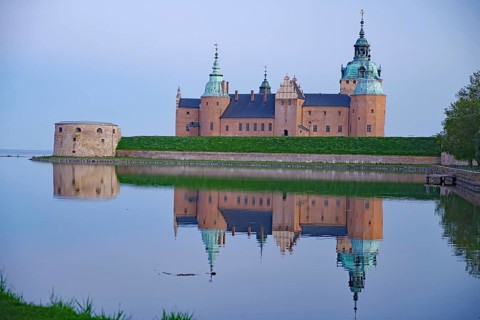 Historic castle at dawn reflected in calm water, Kalmar Slott, Kalmar, Kalmar Län, Sweden