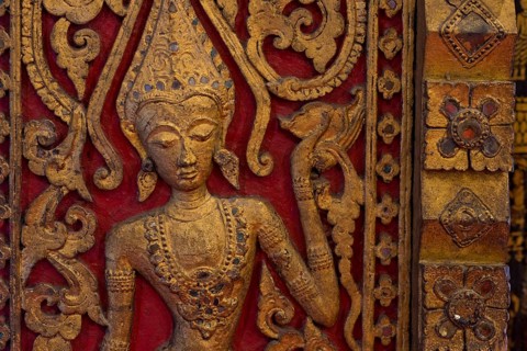 Carved wooden figure of an apsara dancer in the Buddhist Wat Xieng Tong or Vat Xienthong, Thong,