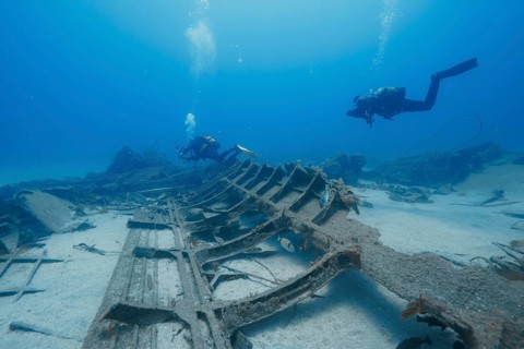 Divers explore a large shipwreck on the ocean floor, meteor wreck dive site, Russian hydrofoil,
