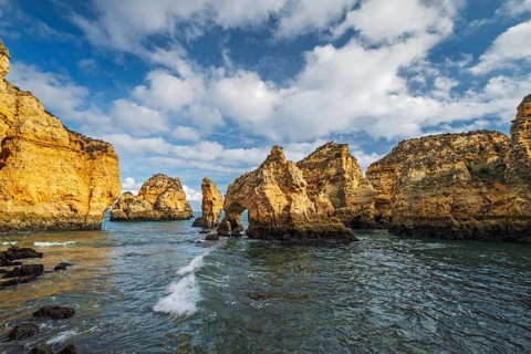 Surf, rocks and sea stacks create an ocean scene at Ponte da Piedade in Lagos, Algarve, Portugal,