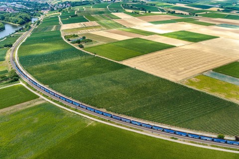Freight train runs parallel to a Neckar loop of the Neckar. Fertile soils and a mild climate are