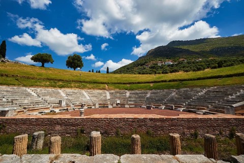 Ancient amphitheatre with green hills and blue sky in the background, Messene Theatre, Ancient