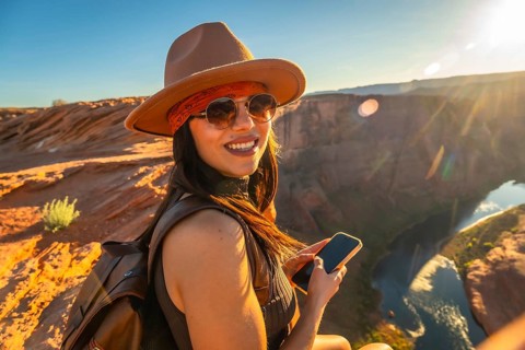 Young woman traveler enjoying the breathtaking panoramic views of horseshoe bend in page, arizona,