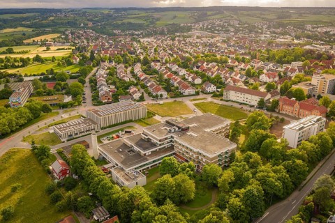 Urban landscape with a large central building surrounded by residential buildings and nature, new